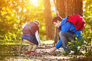 Das Bild zeigt drei Kinder, die am Bach spielen. Foto: www.bayern.by – Jan Greune